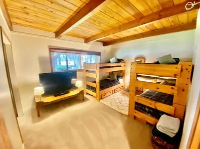 a room with two bunk beds and a television at Newly Renovated Family Lake House, Private Beach! in Tahoma