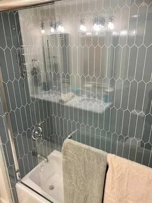 a tiled bathroom with a sink and a mirror at Newly Renovated Family Lake House, Private Beach! in Tahoma