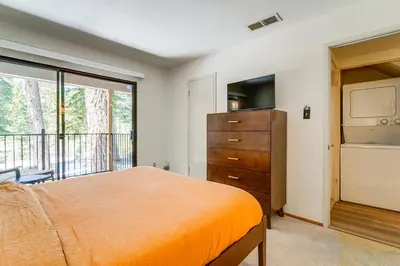 a bedroom with a bed and a dresser and a balcony at Steps to Lake Scenic Carnelian Bay Retreat in Carnelian Bay