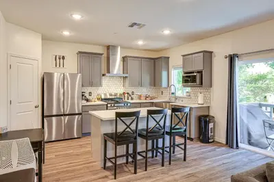 a kitchen with a stainless steel refrigerator and bar stools at Spacious Family Home in Stockton - Pets Welcome! in Stockton