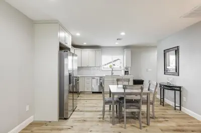 a kitchen with white cabinets and a table and chairs at Pet-Friendly Hughson Getaway, 9 Mi to Modesto! in Hughson