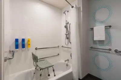 a bathroom with a chair sitting next to a bath tub at Tru By Hilton Lodi in Lodi