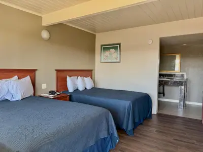 a hotel room with two beds and a fireplace at Regency Inn Fresno in Fresno