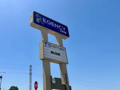 a sign for a energy firm with a stop sign at Regency Inn Fresno in Fresno