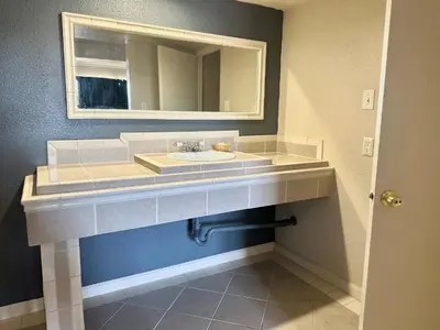 a bathroom with a sink and a mirror at Regency Inn Fresno in Fresno