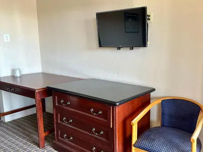 a room with a desk and a tv and a chair at Regency Inn Fresno in Fresno