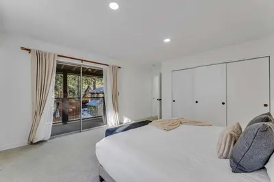 a bedroom with a white bed and a large window at Luxurious 7BR Walk 2 Beach and Bus Stop in Carnelian Bay