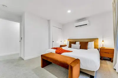 a large white bedroom with a large bed and a bench at Luxurious 7BR Walk 2 Beach and Bus Stop in Carnelian Bay
