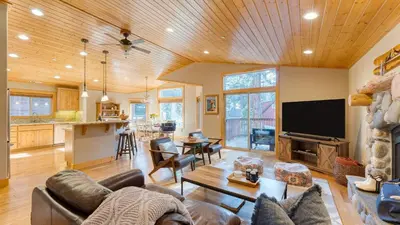 a living room with a couch and a tv and a kitchen at Washoe Chalet by AvantStay Game Room Hot Tub Putting Green Fire Pit in Tahoma