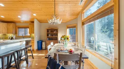 a kitchen and dining room with a table and chairs at Washoe Chalet by AvantStay Game Room Hot Tub Putting Green Fire Pit in Tahoma