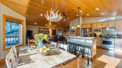 a kitchen with a table with a bowl of fruit on it at Washoe Chalet by AvantStay Game Room Hot Tub Putting Green Fire Pit in Tahoma