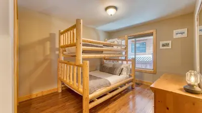a bedroom with two bunk beds and a desk at Washoe Chalet by AvantStay Game Room Hot Tub Putting Green Fire Pit in Tahoma