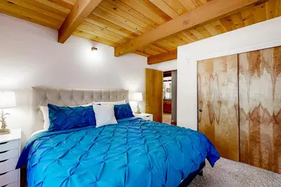 a bedroom with a blue bed with a wooden ceiling at The Venado House in Arnold