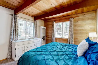 a bedroom with a blue bed and a wooden ceiling at The Venado House in Arnold