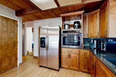 a kitchen with a stainless steel refrigerator and wooden cabinets at The Venado House in Arnold