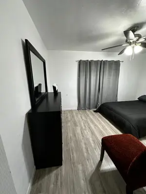 a bedroom with a bed and a mirror on a dresser at Casa Relajante in Visalia