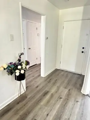 an empty room with a vase of flowers on a tripod at Casa Relajante in Visalia
