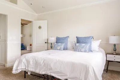 a bedroom with a large white bed with blue pillows at Willow Nest - Sequoia And Kings Canyon Villa - Luxury In Nature in Hoffman Point