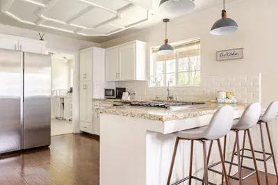 a kitchen with white cabinets and a island with bar stools at Willow Nest - Sequoia And Kings Canyon Villa - Luxury In Nature in Hoffman Point