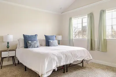 a white bedroom with a large bed with blue pillows at Willow Nest - Sequoia And Kings Canyon Villa - Luxury In Nature in Hoffman Point