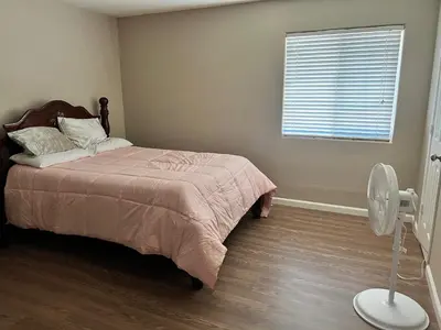 a bedroom with a bed with a fan and a window at Serene 2bed 1bath condo with parking in Fresno