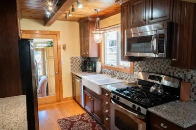 a kitchen with wooden cabinets and a stove top oven at Fern Grove - Hot Tub, Pet Friendly, Walk to Lake! in Tahoe City