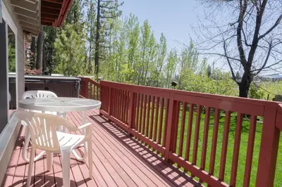a wooden deck with a table and chairs on it at Fern Grove - Hot Tub, Pet Friendly, Walk to Lake! in Tahoe City