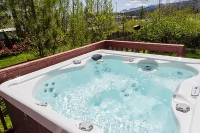 a jacuzzi tub with a view of a yard at Fern Grove - Hot Tub, Pet Friendly, Walk to Lake! in Tahoe City