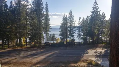 a road with trees and the ocean in the background at Livin' Lake Life in Incline Village