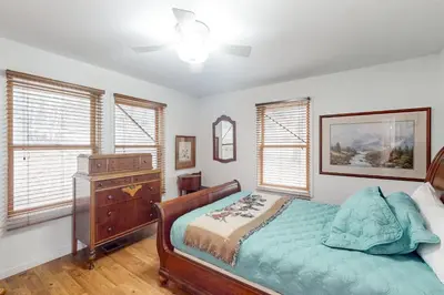 a bedroom with a bed and a dresser and windows at Under The Stars in Shaver Lake