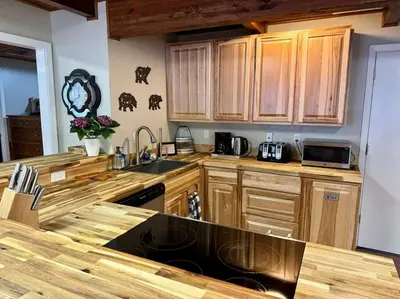 a kitchen with wooden cabinets and a black sink at Camp Cocktail - Cabin in the Heart of the Sierra, Arnold, CA in Arnold