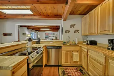 a kitchen with wooden cabinets and a stove top oven at Camp Cocktail - Cabin in the Heart of the Sierra, Arnold, CA in Arnold