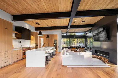 a kitchen with white furniture and wooden ceilings at Creekside Retreat - Near Palisades Tahoe in Olympic Valley