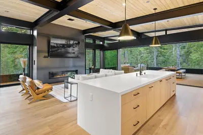 a kitchen with a large white counter and a fireplace at Creekside Retreat - Near Palisades Tahoe in Olympic Valley