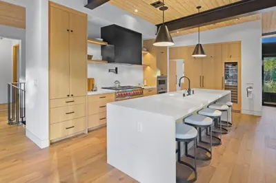 a kitchen with a large white island with bar stools at Creekside Retreat - Near Palisades Tahoe in Olympic Valley