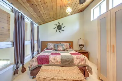 a bedroom with a bed with a spider on the wall at Auburn Cottage with Patios and Garden - 3 Mi to Town! in Auburn