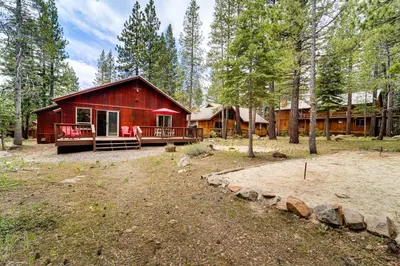 a large red cabin in the woods with trees at Home with Deck and Access to Tahoe Donner Amenities! in Truckee