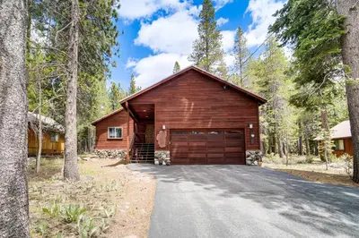 a house with a garage in the woods at Home with Deck and Access to Tahoe Donner Amenities! in Truckee
