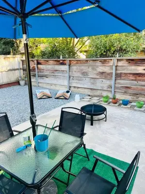 a table and chairs with an umbrella on a patio at Remodeled Oasis in Visalia
