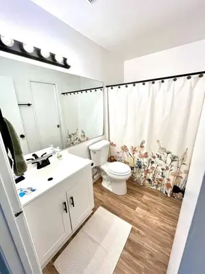 a white bathroom with a toilet and a sink at Remodeled Oasis in Visalia