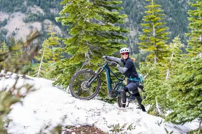 a person riding a bike on a snow covered hill at 2BR Mins to Alpine Base Area Palisades! in Alpine Meadows