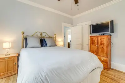 a bedroom with a white bed and a flat screen tv at Walk to Midtown Charming Reno Retreat in Reno