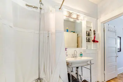 a white bathroom with a shower and a sink at Walk to Midtown Charming Reno Retreat in Reno