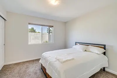 a white bedroom with a bed and a window at 3 Mi to Downtown Reno Charming Condo with Patio in Reno
