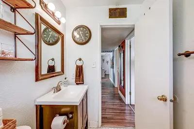 a bathroom with a sink and clocks on the wall at Family-Friendly Clovis Home with Gas Grill and Patio! in Clovis