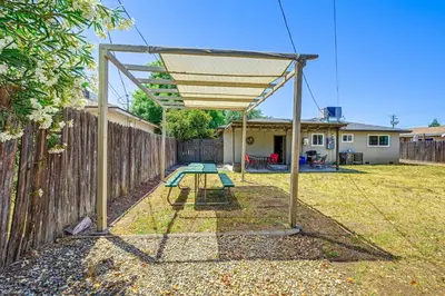 a picnic table under a canopy in a backyard at Family-Friendly Clovis Home with Gas Grill and Patio! in Clovis