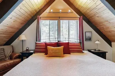 a bedroom with a bed with red pillows and a window at Tranquil Family Cabin in Incline Village