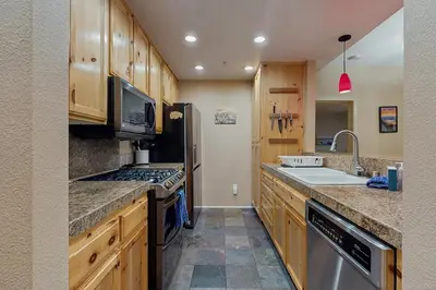a kitchen with wooden cabinets and a sink and a stove at Tavern Inn #38 in Olympic Valley