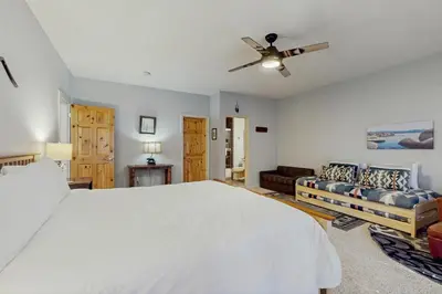 a bedroom with a large white bed and a couch at Tavern Inn #38 in Olympic Valley
