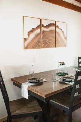 a dining room table with two chairs and a wooden table with glasses at Redwood Grove in Sequoia and Kings Canyon National Park in Wilsonia